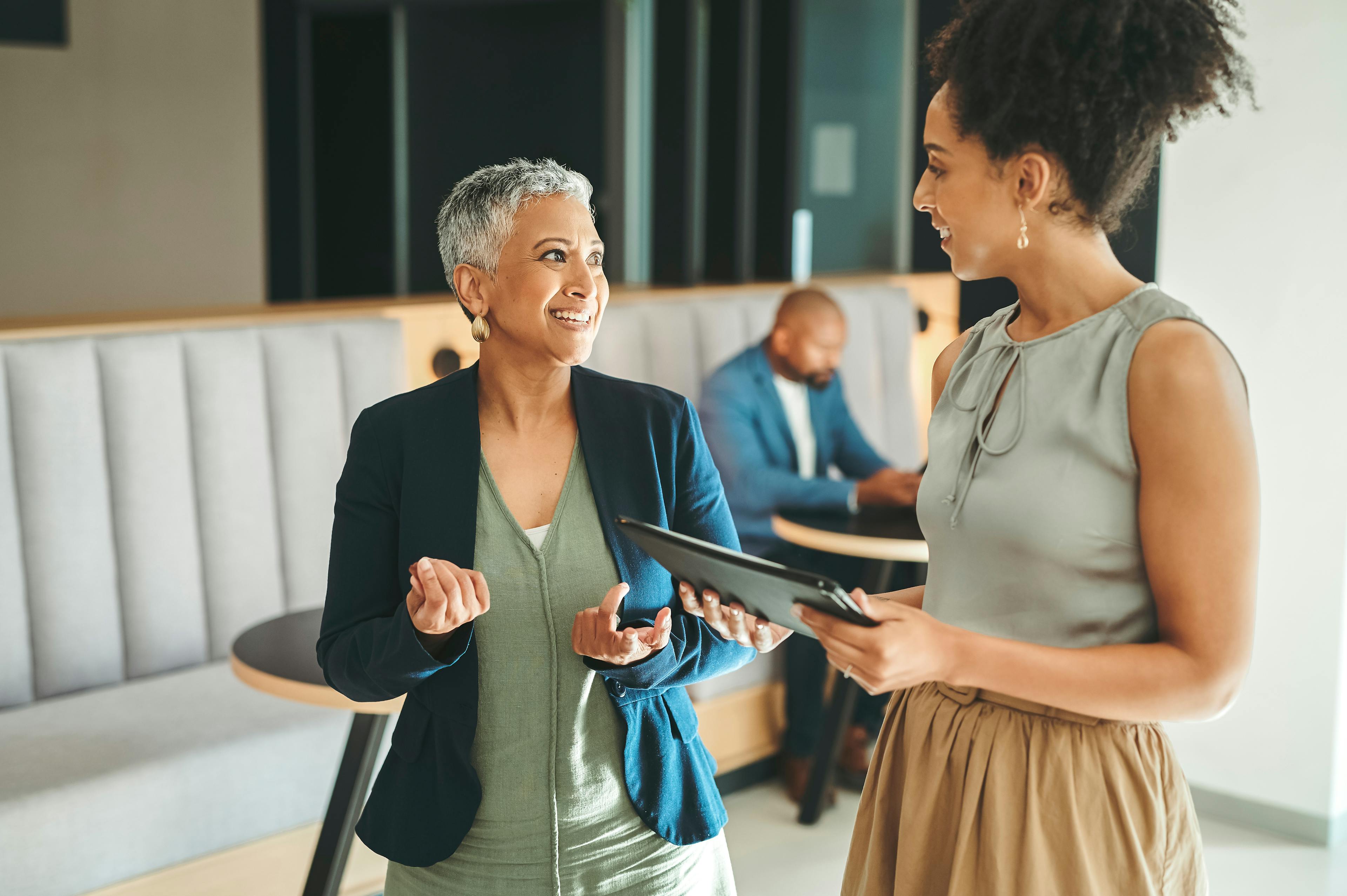 Two women standing next to one another in conversation