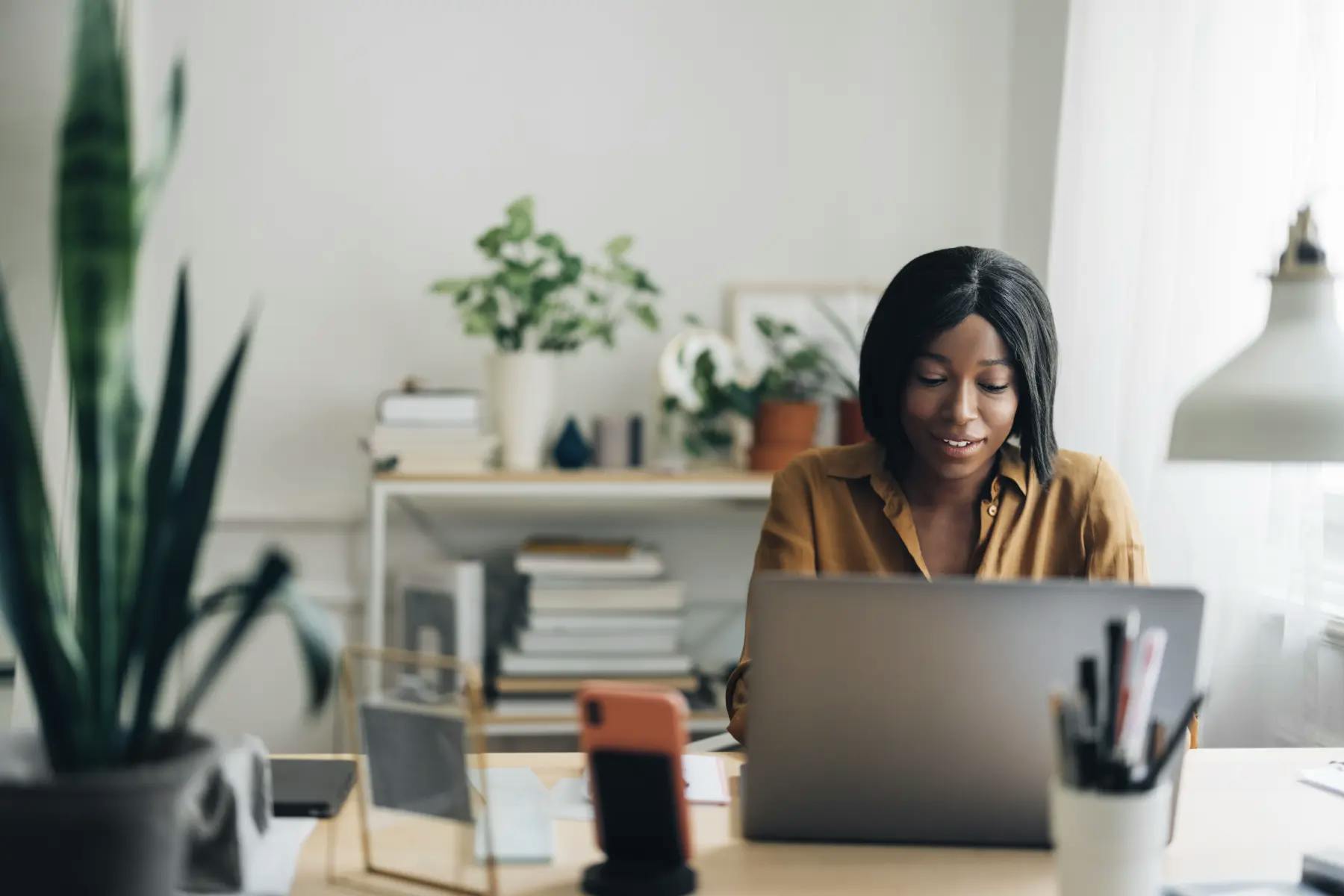 A woman sitting at her desk, working on her laptop